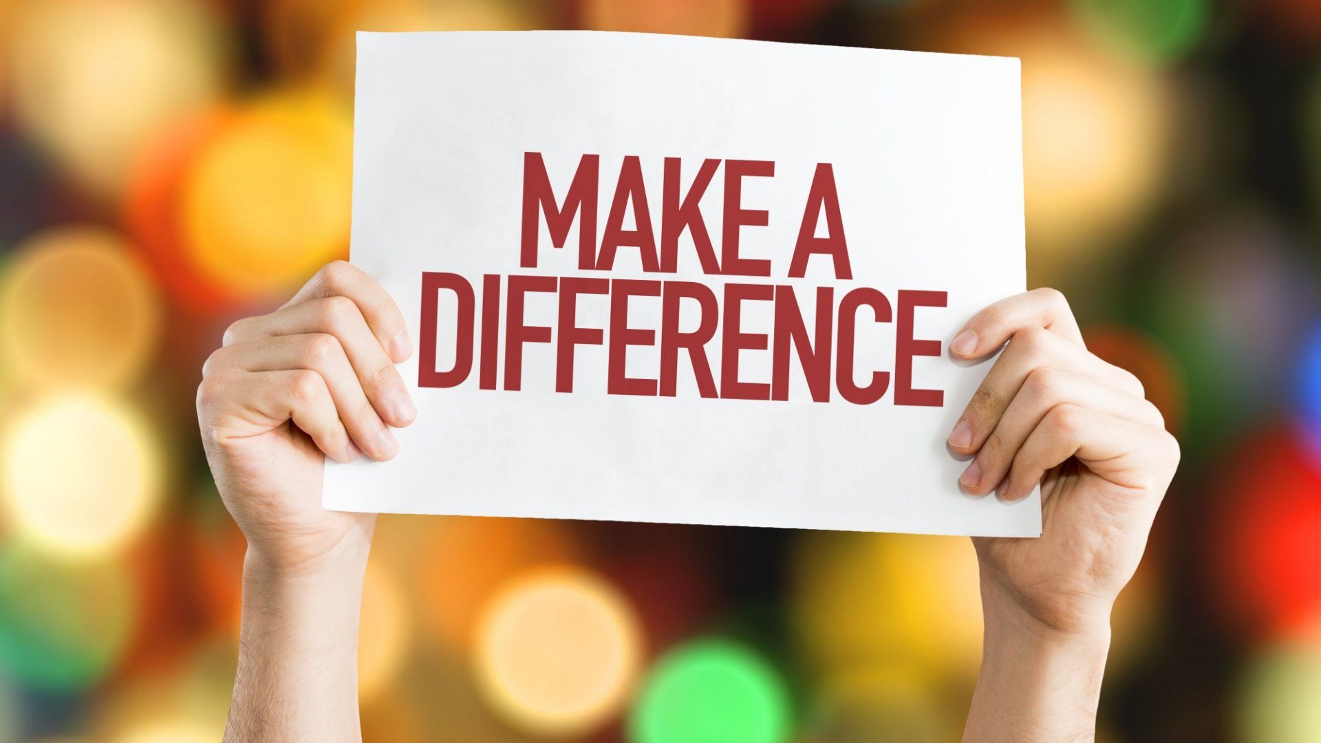 Hands holding a sign that reads Make a Difference